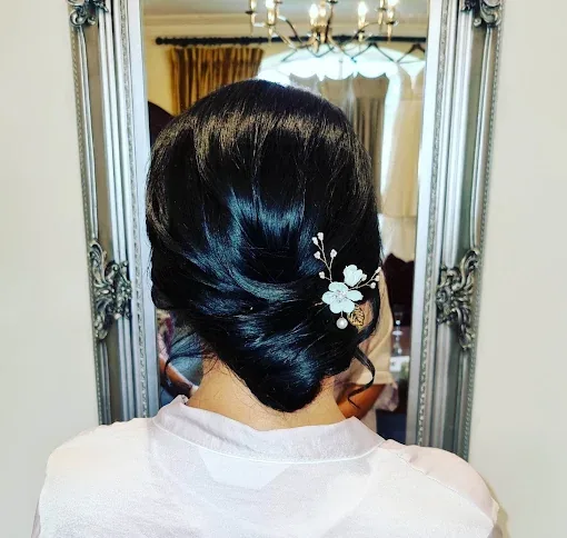 Dark bridal updo dressed with a floral pin